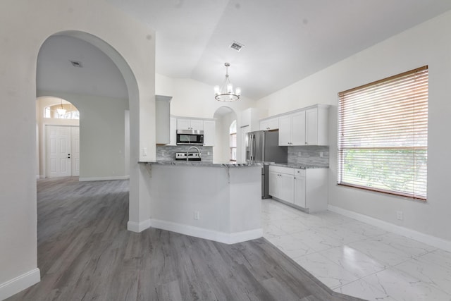 5761 Spanish River Rd, Fort Pierce, FL 34951 - kitchen with appliances with stainless steel finishes, a peninsula, arched walkways, tasteful backsplash, and vaulted ceiling