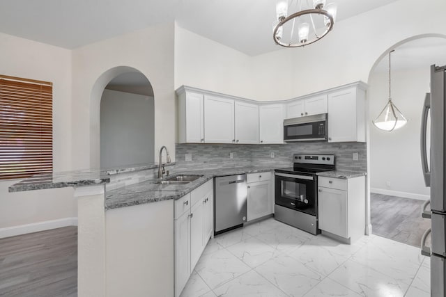 5761 Spanish River Rd, Fort Pierce, FL 34951 - kitchen featuring appliances with stainless steel finishes, a sink, arched walkways, and a peninsula