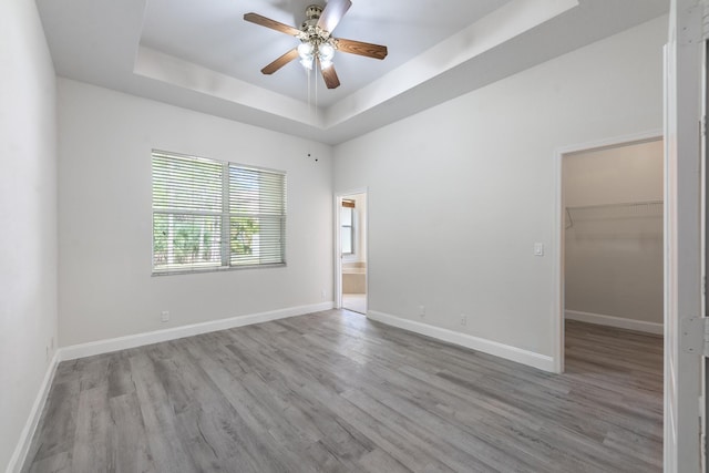 5761 Spanish River Rd, Fort Pierce, FL 34951 - empty room featuring a raised ceiling, wood finished floors, a ceiling fan, and baseboards
