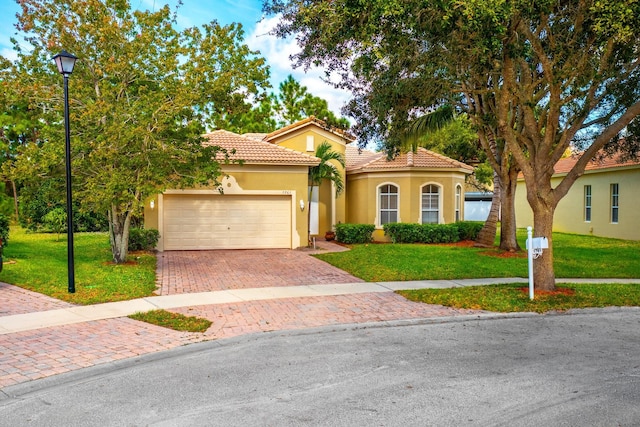5761 Spanish River Rd, Fort Pierce, FL 34951 - mediterranean / spanish home featuring stucco siding, a tiled roof, decorative driveway, and a front lawn