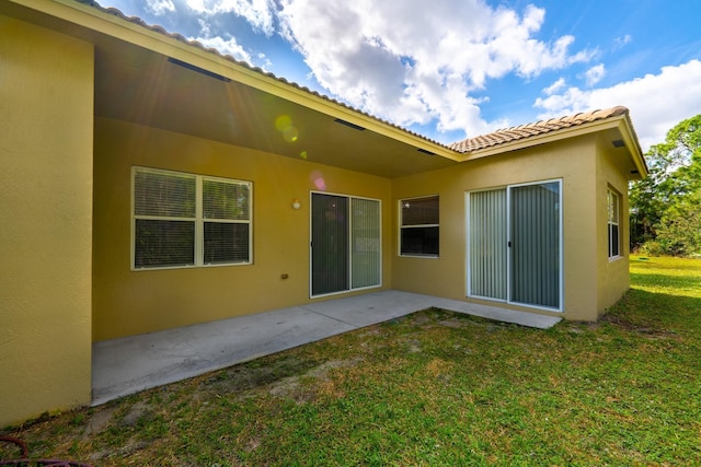 5761 Spanish River Rd, Fort Pierce, FL 34951 - rear view of house with a yard, stucco siding, and a patio area