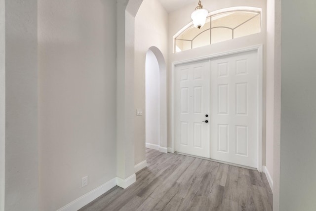 5761 Spanish River Rd, Fort Pierce, FL 34951 - foyer featuring arched walkways, wood finished floors, and baseboards