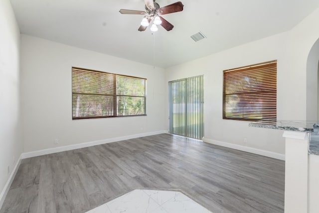 5761 Spanish River Rd, Fort Pierce, FL 34951 - empty room featuring wood finished floors, ceiling fan, arched walkways, and baseboards