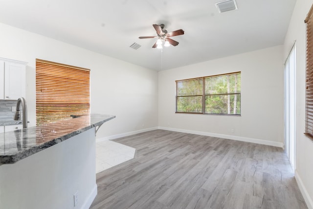 5761 Spanish River Rd, Fort Pierce, FL 34951 - unfurnished living room featuring light wood-style floors, ceiling fan, and baseboards
