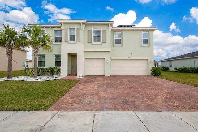 7499 NW Deysbrook Ln, Port Saint Lucie, FL 34987 - townhome / multi-family property featuring a garage, decorative driveway, solar panels, and a front yard