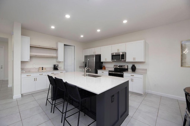 7499 NW Deysbrook Ln, Port Saint Lucie, FL 34987 - kitchen featuring appliances with stainless steel finishes, a sink, open shelves, a kitchen bar, and light countertops