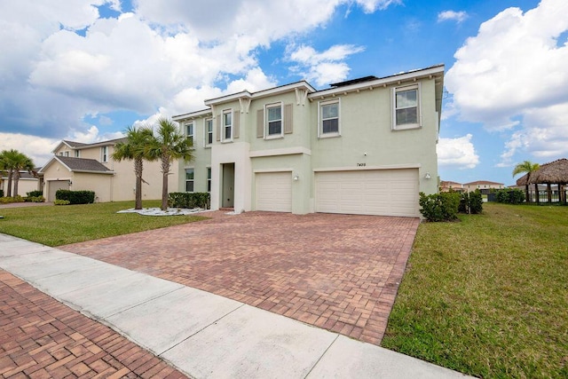 7499 NW Deysbrook Ln, Port Saint Lucie, FL 34987 - view of front of house with a garage, stucco siding, decorative driveway, and a front lawn