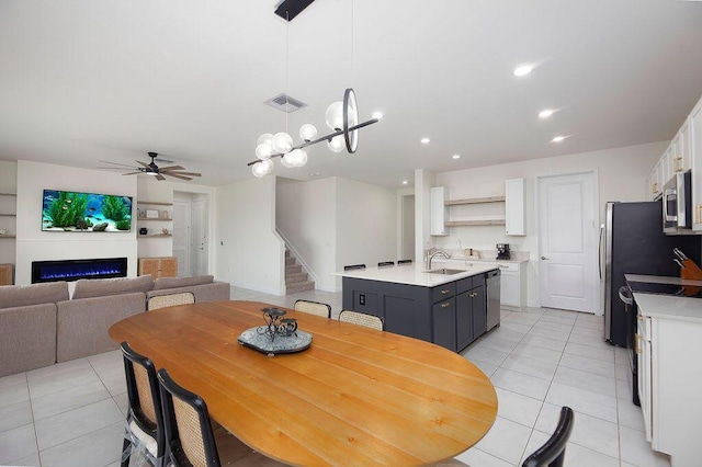 7499 NW Deysbrook Ln, Port Saint Lucie, FL 34987 - dining room featuring stairs, light tile patterned floors, ceiling fan, recessed lighting, and a glass covered fireplace