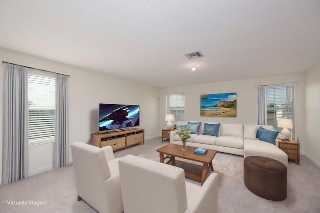 7499 NW Deysbrook Ln, Port Saint Lucie, FL 34987 - living area with healthy amount of natural light, baseboards, and light carpet