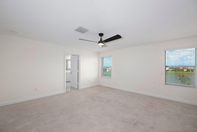 7499 NW Deysbrook Ln, Port Saint Lucie, FL 34987 - unfurnished room featuring a ceiling fan, plenty of natural light, light colored carpet, and baseboards
