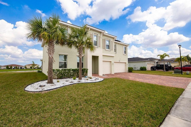 7499 NW Deysbrook Ln, Port Saint Lucie, FL 34987 - view of front facade featuring decorative driveway, an attached garage, stucco siding, and a front yard
