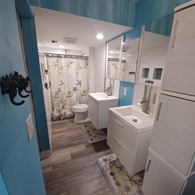 54 Piedmont Unit B, Delray Beach, FL 33484 - bathroom featuring wood finished floors, toilet, two vanities, and a shower with shower curtain
