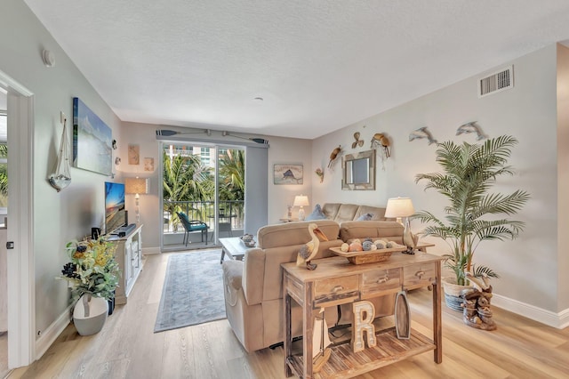 804 E Windward Way Unit 404, Lantana, FL 33462 - living area featuring light wood-style floors, baseboards, and a textured ceiling
