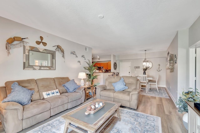 804 E Windward Way Unit 404, Lantana, FL 33462 - living area featuring light wood-type flooring, a chandelier, baseboards, and a textured ceiling