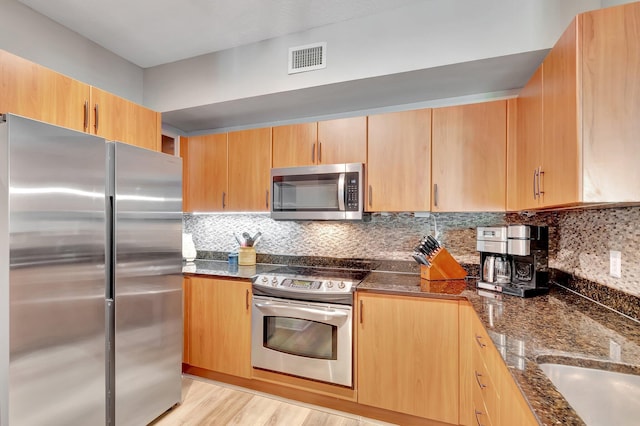 804 E Windward Way Unit 404, Lantana, FL 33462 - kitchen featuring stainless steel appliances, dark stone counters, backsplash, and light brown cabinets