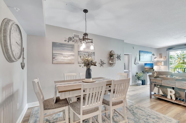 804 E Windward Way Unit 404, Lantana, FL 33462 - dining room with light wood-style floors, a chandelier, and baseboards