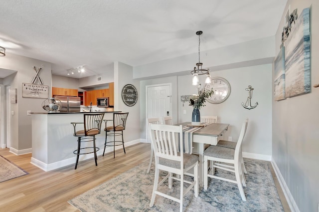 804 E Windward Way Unit 404, Lantana, FL 33462 - dining area with light wood-style floors, baseboards, rail lighting, and a textured ceiling