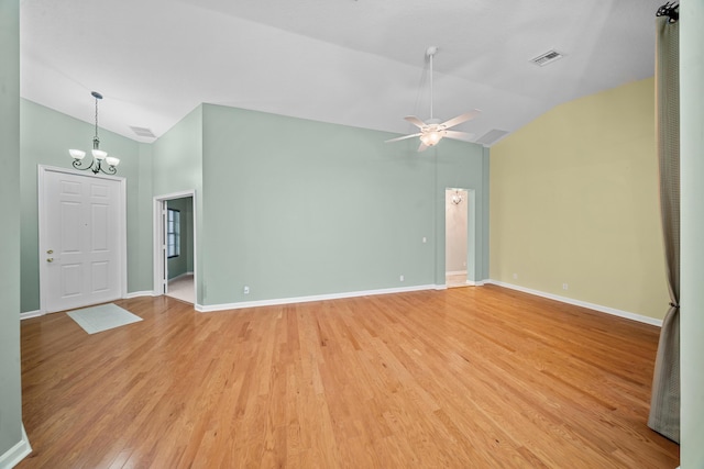 415 NW Granville St, Port Saint Lucie, FL 34986 - empty room with a chandelier, light wood-style floors, ceiling fan, baseboards, and high vaulted ceiling