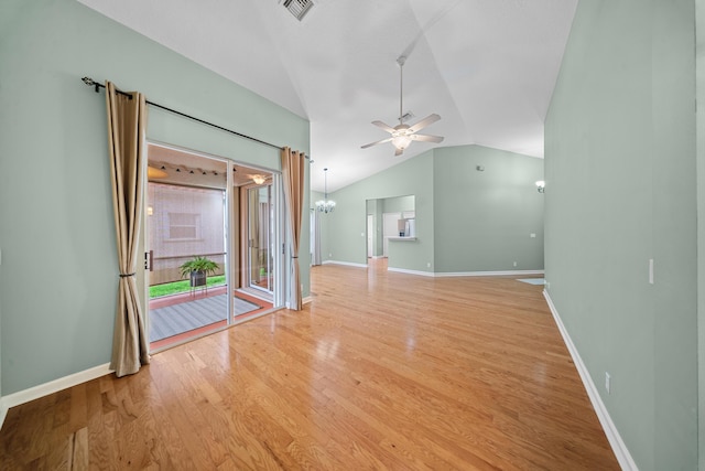 415 NW Granville St, Port Saint Lucie, FL 34986 - unfurnished living room with lofted ceiling, a ceiling fan, a chandelier, light wood-type flooring, and baseboards