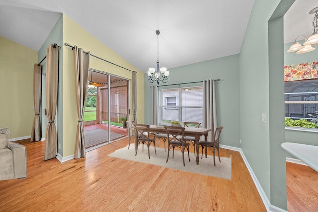 415 NW Granville St, Port Saint Lucie, FL 34986 - dining area with a chandelier, vaulted ceiling, light wood-type flooring, and baseboards