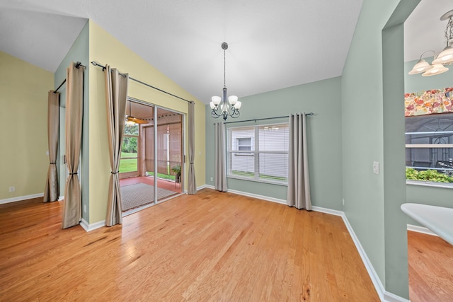 415 NW Granville St, Port Saint Lucie, FL 34986 - unfurnished dining area featuring a chandelier, lofted ceiling, light wood-style floors, and baseboards
