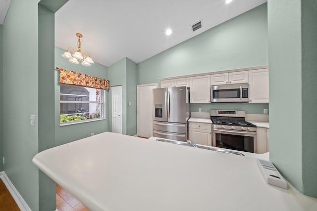 415 NW Granville St, Port Saint Lucie, FL 34986 - kitchen featuring stainless steel appliances, a chandelier, a peninsula, light countertops, and pendant lighting