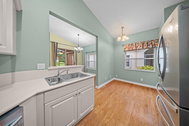 415 NW Granville St, Port Saint Lucie, FL 34986 - kitchen featuring appliances with stainless steel finishes, a chandelier, a sink, vaulted ceiling, and white cabinetry