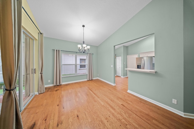 415 NW Granville St, Port Saint Lucie, FL 34986 - unfurnished dining area with a chandelier, lofted ceiling, baseboards, and light wood-style floors