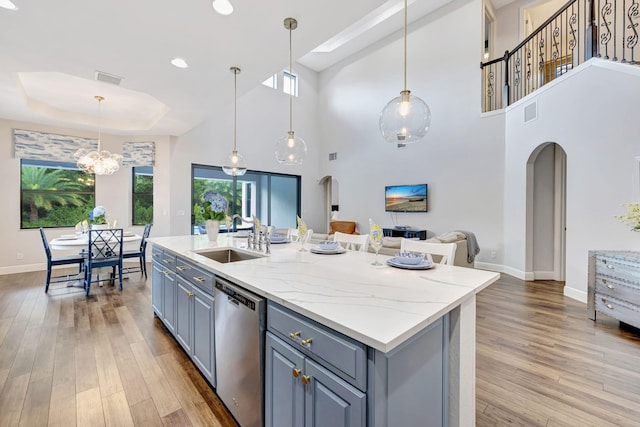 8271 Canopy Ter, Parkland, FL 33076 - kitchen with dishwasher, a sink, baseboards, light wood-style floors, and a towering ceiling