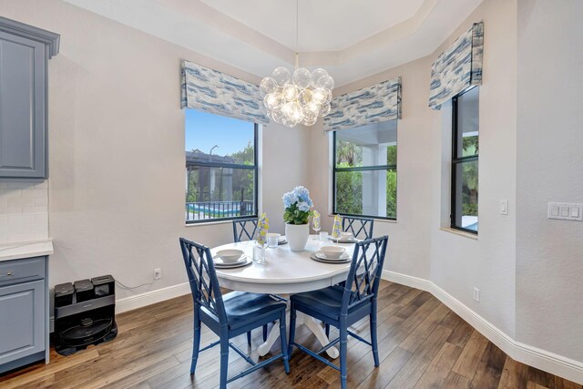 8271 Canopy Ter, Parkland, FL 33076 - dining space with dark wood-type flooring, a chandelier, baseboards, and a tray ceiling