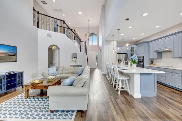 8271 Canopy Ter, Parkland, FL 33076 - living area with arched walkways, a towering ceiling, wood finished floors, recessed lighting, and baseboards