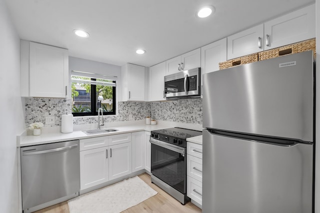 1325 S Flagler Ave Unit 104, Pompano Beach, FL 33060 - kitchen with appliances with stainless steel finishes, a sink, light wood-style floors, white cabinets, and light countertops