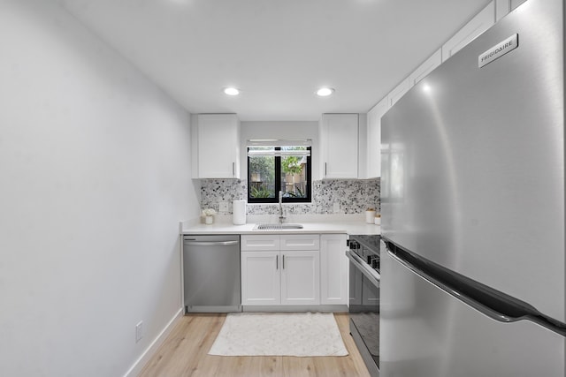 1325 S Flagler Ave Unit 104, Pompano Beach, FL 33060 - kitchen featuring appliances with stainless steel finishes, a sink, light wood-type flooring, white cabinets, and decorative backsplash