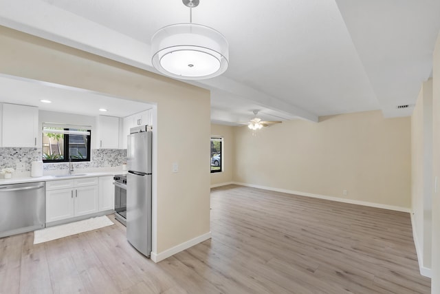 1325 S Flagler Ave Unit 104, Pompano Beach, FL 33060 - kitchen featuring stainless steel appliances, open floor plan, light wood finished floors, backsplash, and a sink