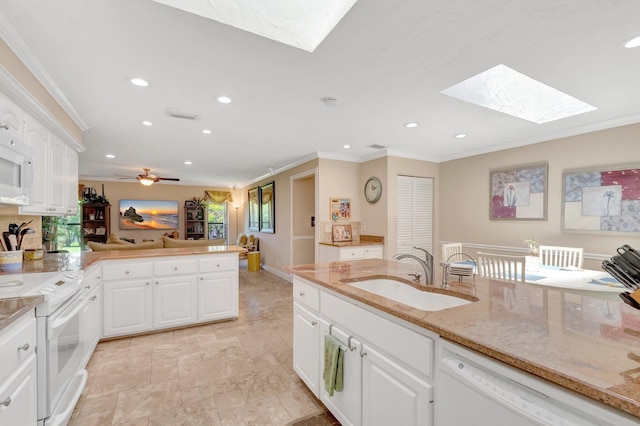 15385 Cedar Bluff Pl, Wellington, FL 33414 - kitchen featuring a skylight, white appliances, a sink, crown molding, and a peninsula