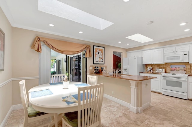 15385 Cedar Bluff Pl, Wellington, FL 33414 - kitchen with white appliances, a skylight, a peninsula, white cabinets, and recessed lighting