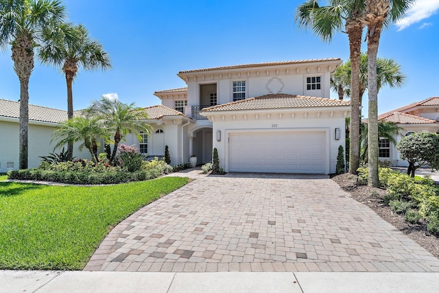220 Carina Dr, Jupiter, FL 33478 - mediterranean / spanish house with stucco siding, an attached garage, decorative driveway, a tiled roof, and a front lawn