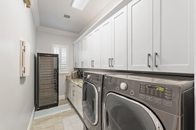 220 Carina Dr, Jupiter, FL 33478 - washroom featuring cabinet space, washer and dryer, baseboards, ornamental molding, and beverage cooler