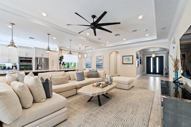 220 Carina Dr, Jupiter, FL 33478 - living room featuring arched walkways, a ceiling fan, baseboards, crown molding, and a tray ceiling