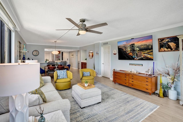 2424 N Federal Hwy Unit 315, Boynton Beach, FL 33435 - living room featuring light wood finished floors, ceiling fan, ornamental molding, a textured ceiling, and baseboards
