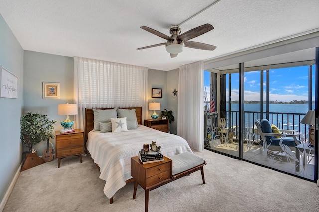 2424 N Federal Hwy Unit 315, Boynton Beach, FL 33435 - bedroom featuring access to outside, carpet floors, a wall of windows, a ceiling fan, and a water view