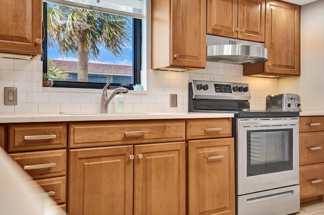 2424 N Federal Hwy Unit 315, Boynton Beach, FL 33435 - kitchen featuring stainless steel electric stove, under cabinet range hood, light countertops, a sink, and brown cabinetry