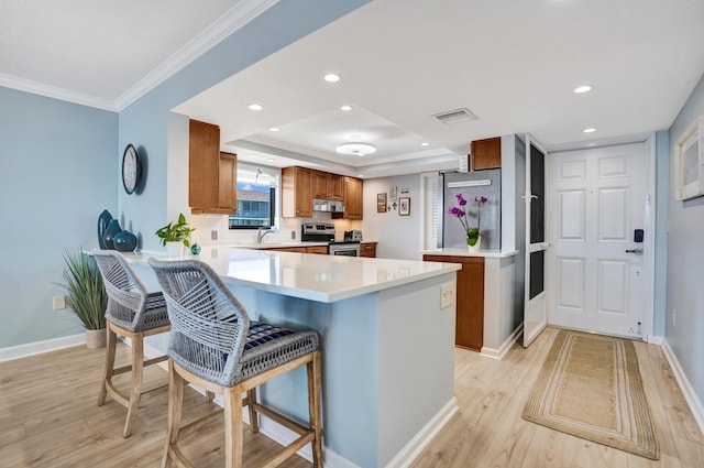 2424 N Federal Hwy Unit 315, Boynton Beach, FL 33435 - kitchen featuring stainless steel electric range oven, brown cabinetry, a peninsula, light wood-style floors, and under cabinet range hood