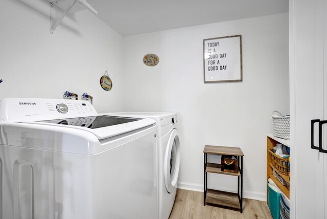 2424 N Federal Hwy Unit 315, Boynton Beach, FL 33435 - washroom featuring washing machine and clothes dryer, light wood-type flooring, and baseboards