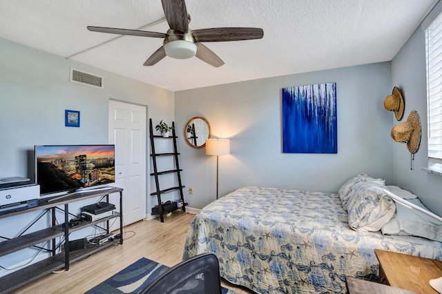 2424 N Federal Hwy Unit 315, Boynton Beach, FL 33435 - bedroom featuring wood finished floors, a textured ceiling, multiple windows, a ceiling fan, and baseboards