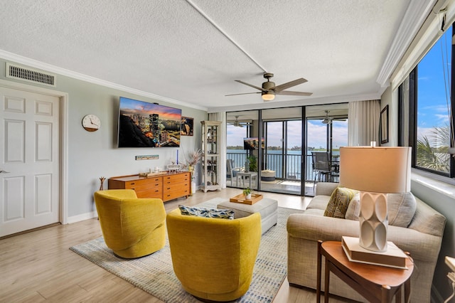 2424 N Federal Hwy Unit 315, Boynton Beach, FL 33435 - living room featuring crown molding, light wood-type flooring, ceiling fan, a textured ceiling, and expansive windows