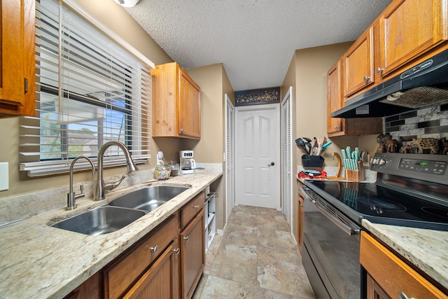 7201 N Blvd, Fort Pierce, FL 34951 - kitchen with black electric range, a sink, under cabinet range hood, light stone finish flooring, and brown cabinetry