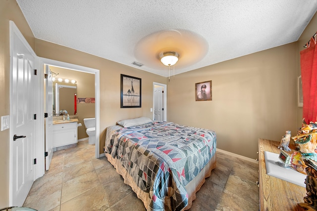 7201 N Blvd, Fort Pierce, FL 34951 - bedroom featuring a textured ceiling, baseboards, light stone finish floors, ensuite bath, and a ceiling fan