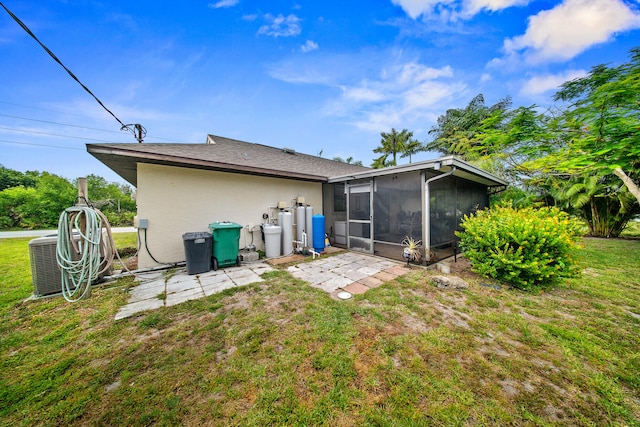 7201 N Blvd, Fort Pierce, FL 34951 - rear view of house featuring a sunroom, central AC unit, a yard, and stucco siding