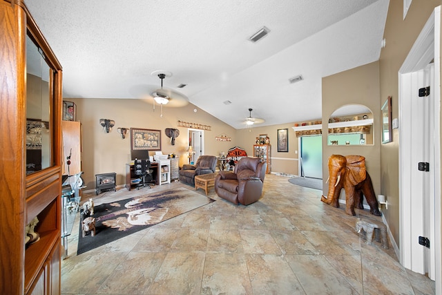 7201 N Blvd, Fort Pierce, FL 34951 - living room featuring a ceiling fan, vaulted ceiling, a wood stove, stone finish flooring, and a textured ceiling